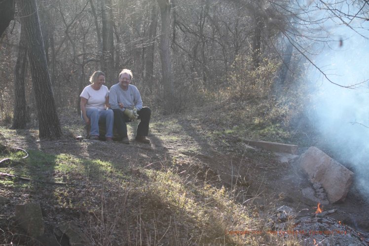 Lisa and her friend Doug enjoy the warmth of the fire and the beauty of the woodlands.